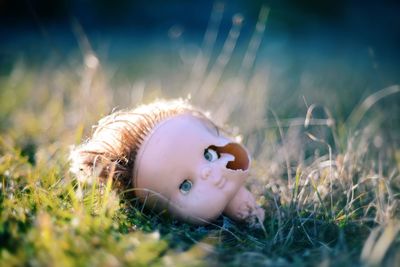 Close-up of broken doll on grass