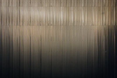 Light reflected blurred on a wall covered with sheet metal strips