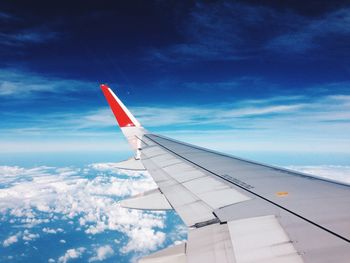 Airplane wing against cloudy sky