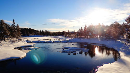 Sun shining over snow covered landscape