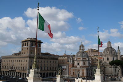 Low angle view of flags in city against sky