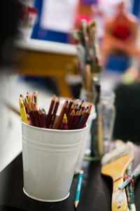 Close-up of multi colored pencils in container on table