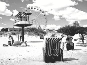 Ferris wheel on beach against sky