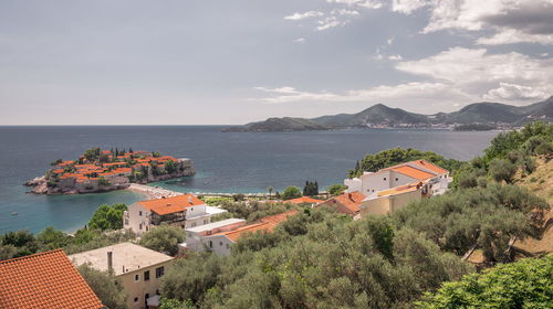 High angle view of townscape by sea against sky