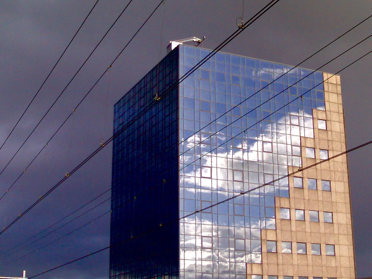 architecture, built structure, low angle view, building exterior, cable, power line, sky, connection, modern, city, building, electricity, electricity pylon, outdoors, no people, power supply, blue, office building, day, tall - high