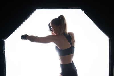 Side view of woman standing against wall