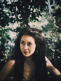 Portrait of beautiful woman against trees