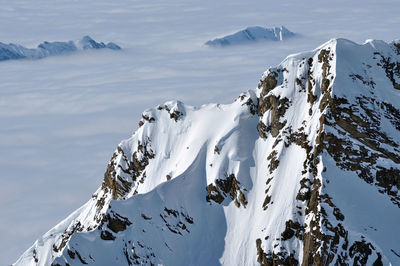 Snow covered high mountains, fog and clouds raising from above. alps, austria