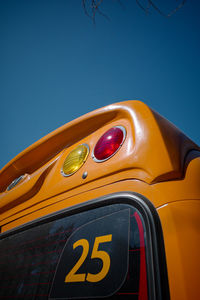 Close-up of yellow car against blue sky