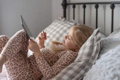 Cute girl using digital tablet at home