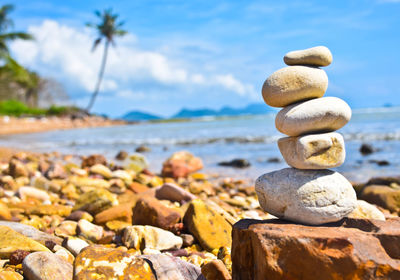 Stack of pebbles on beach against sky