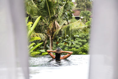 Rear view of woman in swimming pool