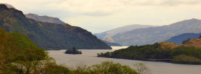 Scenic view of river and mountains against sky