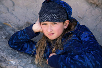 Boy laying on rocks looking directly into camera