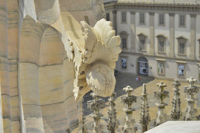 Close-up of statue against historic building