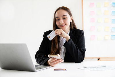 Businesswoman using laptop while sitting on table