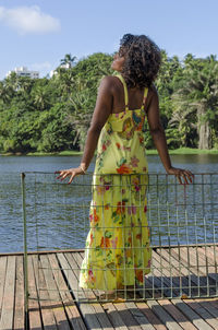 Rear view of woman standing by railing