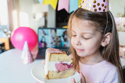 Cute girl holding cake in plate