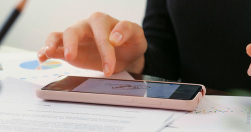 Digital signature on smartphone screen with woman hand. sign document of deal at work in office