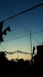 Low angle view of silhouette fence against sky at dusk