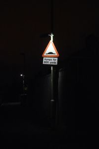 Illuminated road sign at night