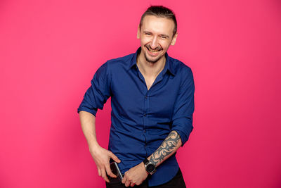 Portrait of a smiling young man against red background