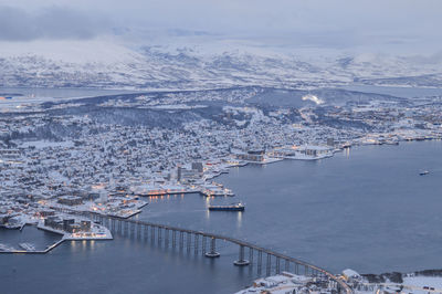 High angle view of city by sea against sky