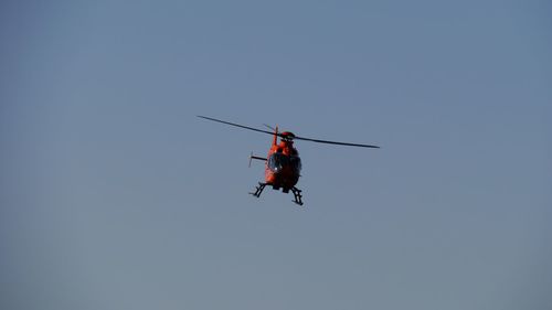Low angle view of helicopter flying in clear sky