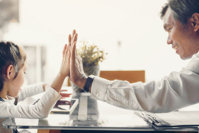 Side view of a couple sitting on table