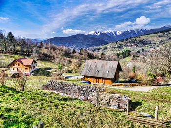 Scenic view of field by buildings against sky