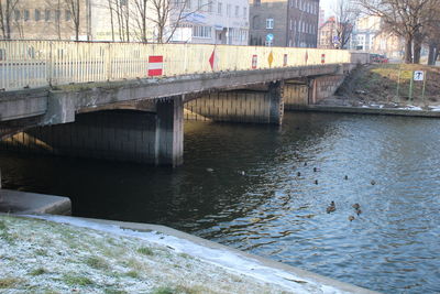 Bridge over river in city against sky