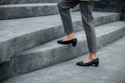 Low section of woman walking on footpath