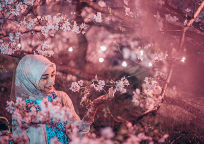 High angle view of woman and pink cherry blossom