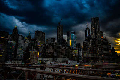 Illuminated buildings in city against sky at dusk