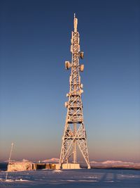 Tower in the snow against clear blue sky