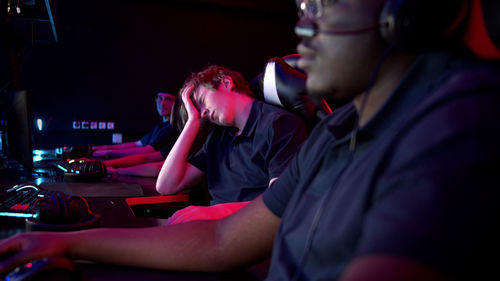 People playing video game in darkroom