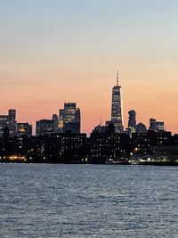 Illuminated buildings in city at sunset