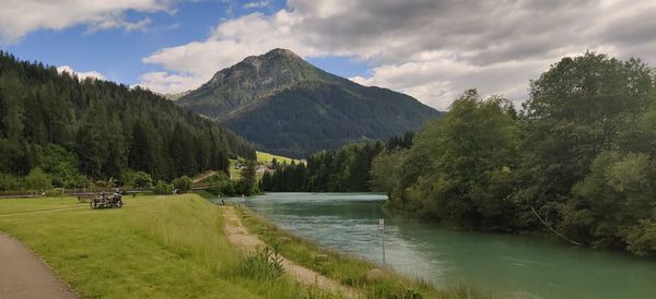 Scenic view of river by trees against sky