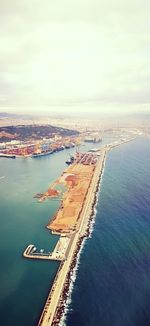 High angle view of city by sea against sky