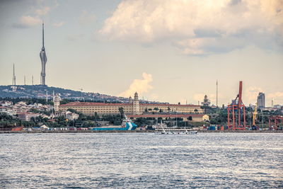 View of buildings at waterfront against cloudy sky