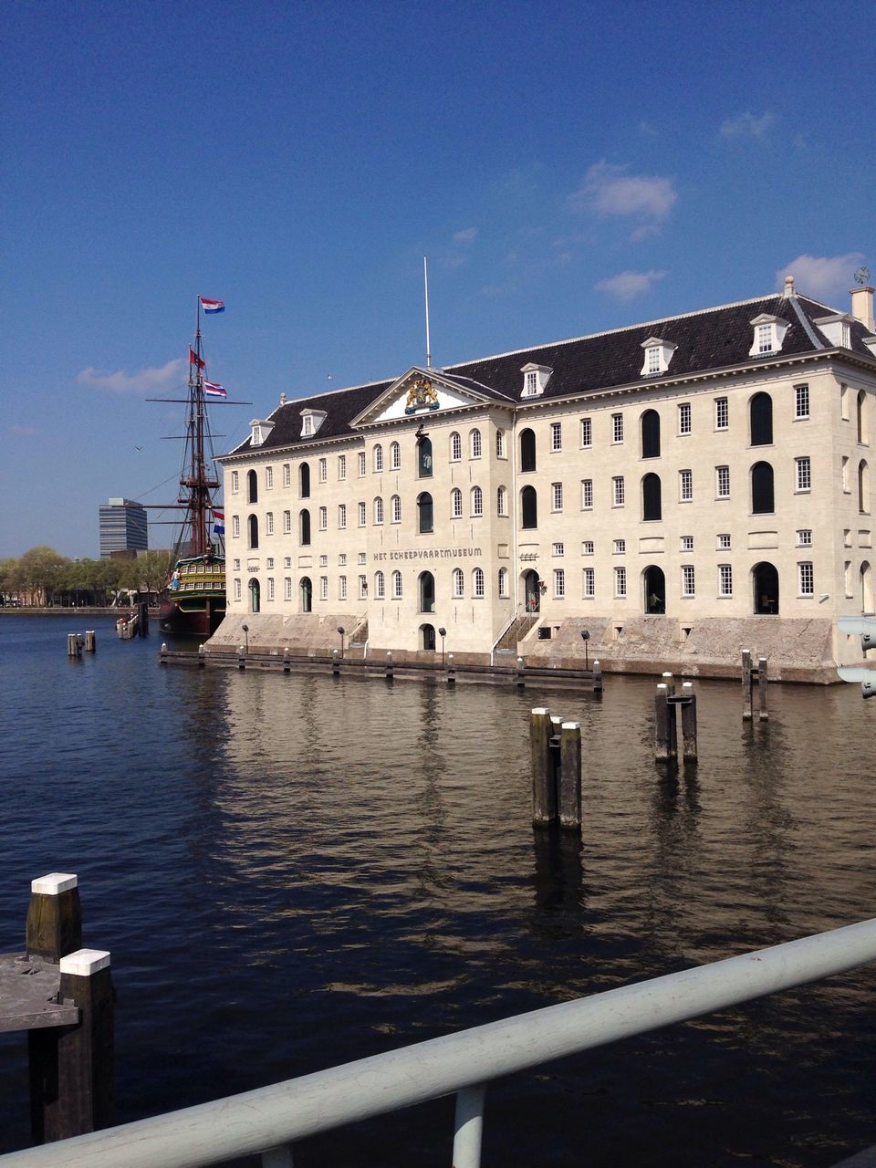 building exterior, architecture, built structure, water, nautical vessel, sky, blue, waterfront, transportation, moored, sea, city, residential building, residential structure, mode of transport, building, harbor, canal, boat, day