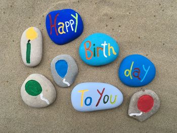 High angle view of multi colored text on pebbles at beach