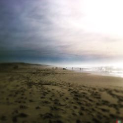 Scenic view of beach against cloudy sky