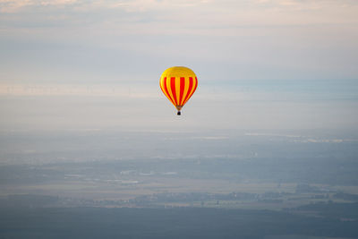 Hot air balloon flying against sky during sunset