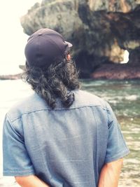 There is a man starring at the sea wall alone. calmness makes him relax