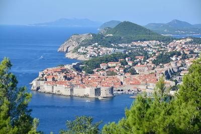 High angle view of townscape by sea against sky