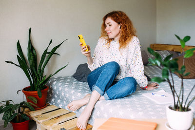 Young woman using mobile phone on table