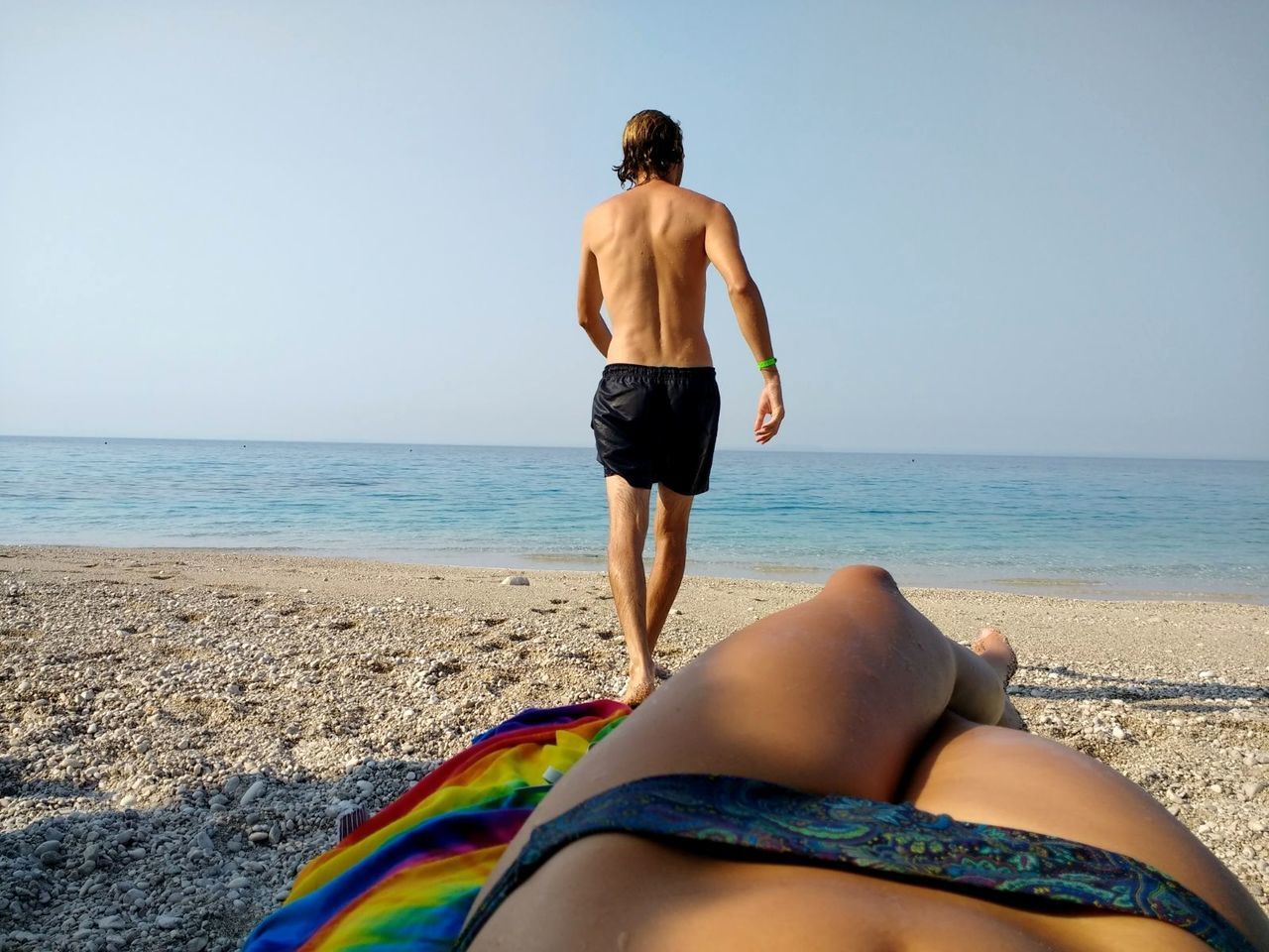 LOW SECTION OF MAN STANDING AT BEACH