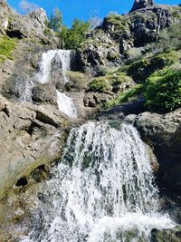 Scenic view of waterfall against sky