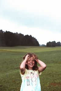 Portrait of a smiling young woman standing on field